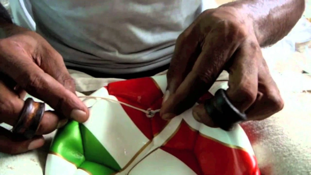 Worker stitching the panels of a GAA ball during manufacturing